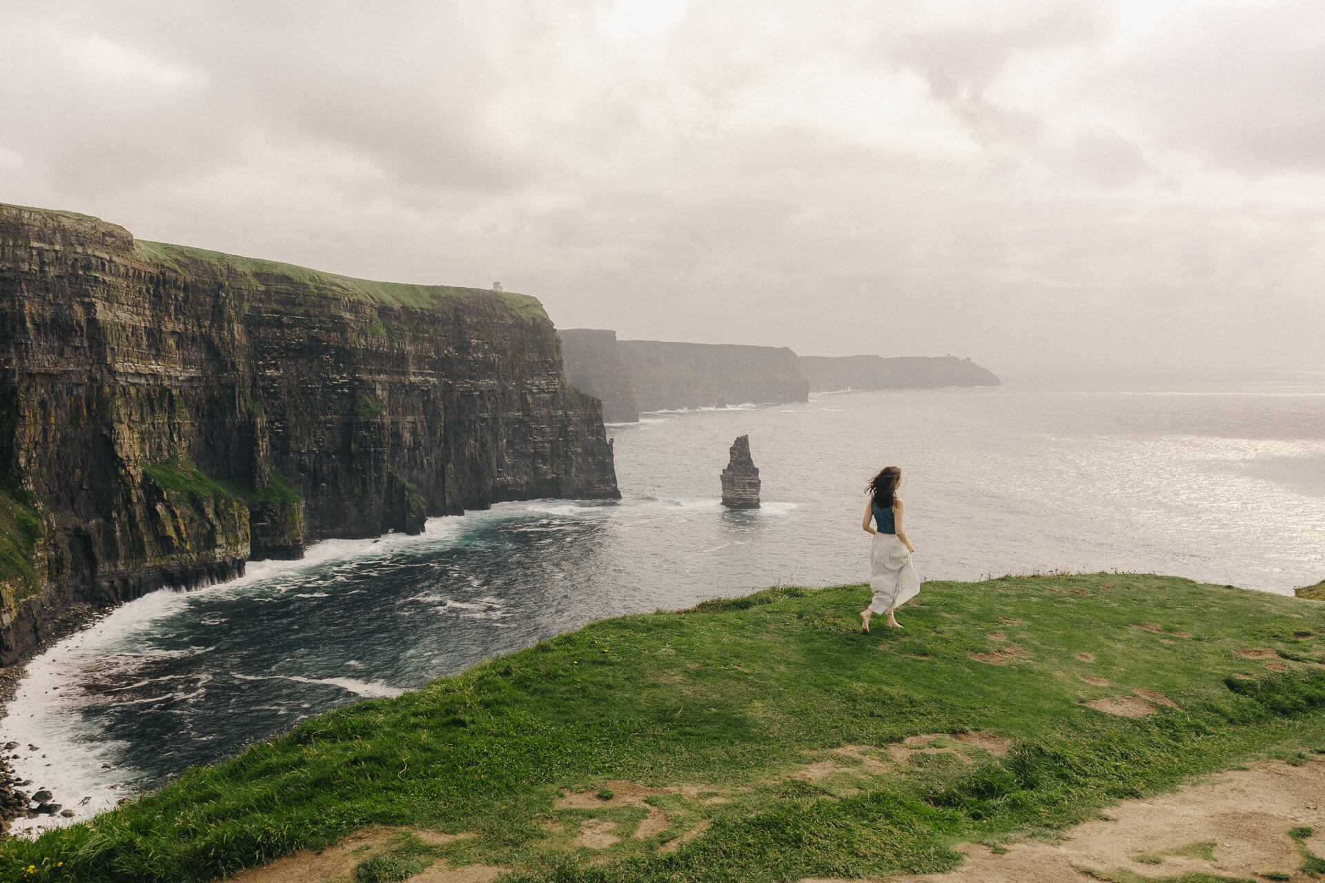 Girl walking at The Cliffs of Moher in Ireland